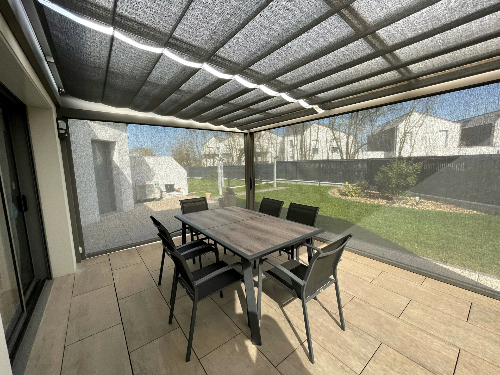 Terrasse moderne avec pergola et mobilier de jardin.