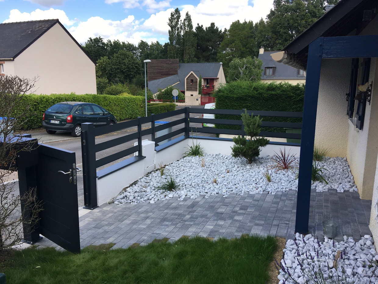 Jardin devant maison avec clôture moderne.