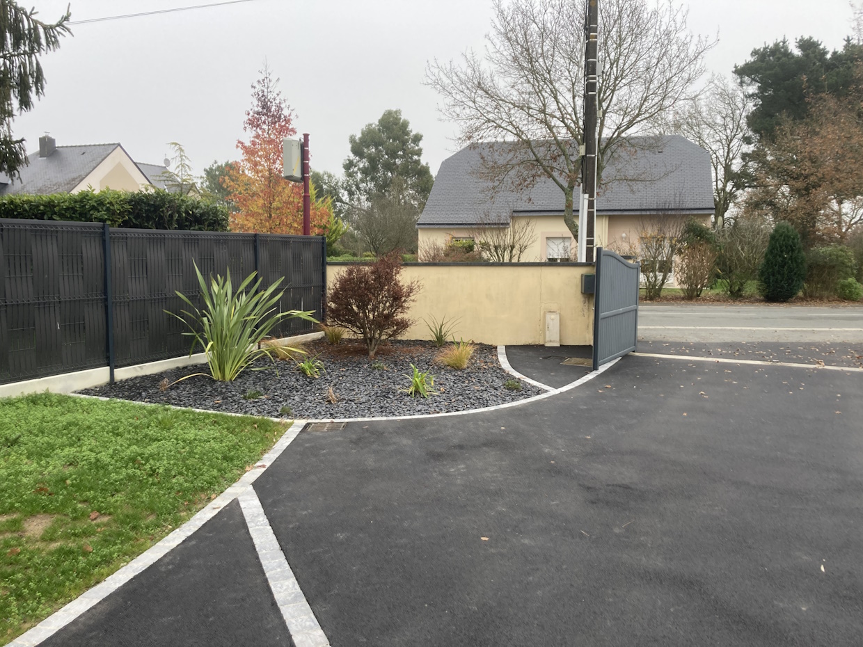 Entrée maison moderne avec jardin et portail.