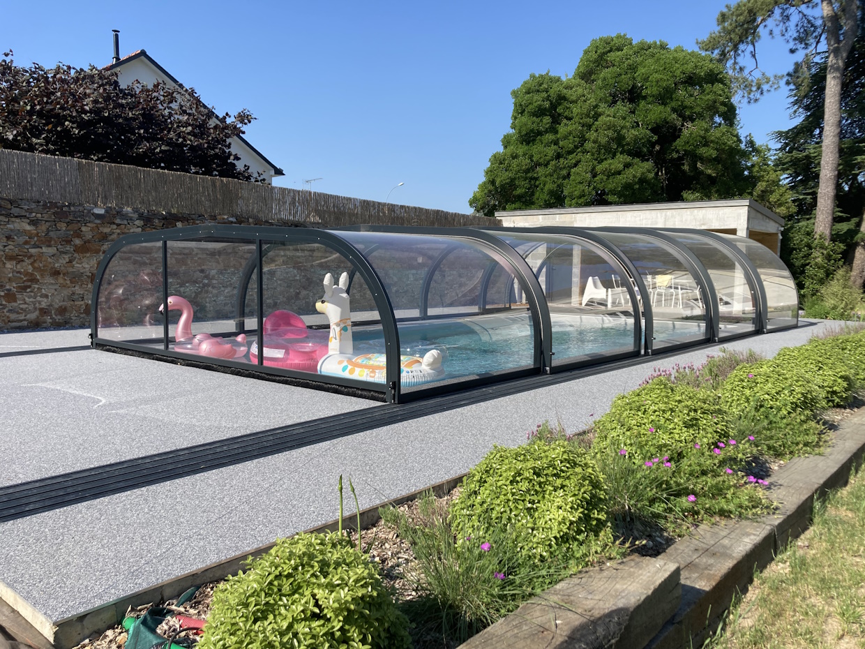 Piscine couverte avec abri télescopique et bouées.