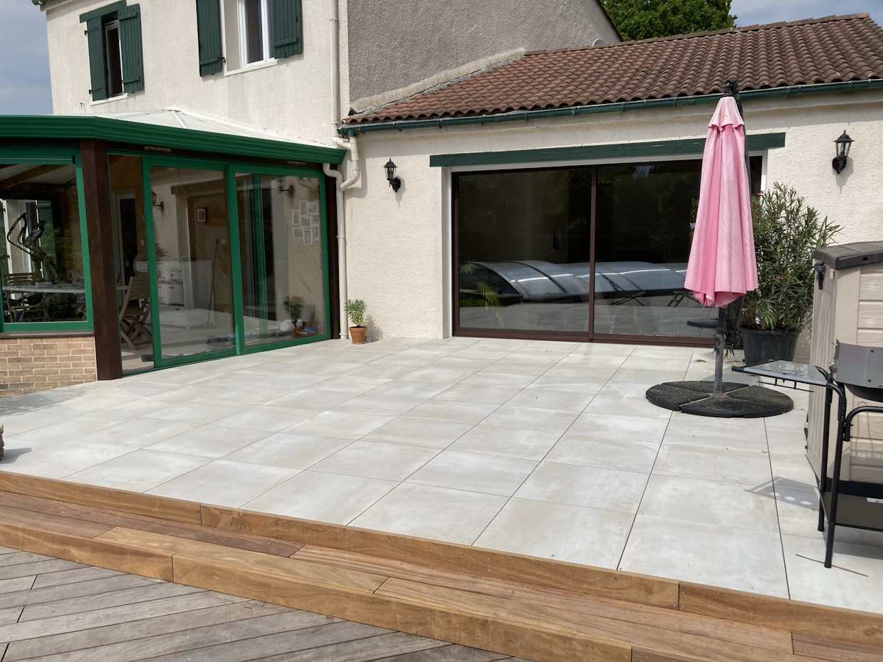 Terrasse moderne avec mobilier de jardin et parasol.