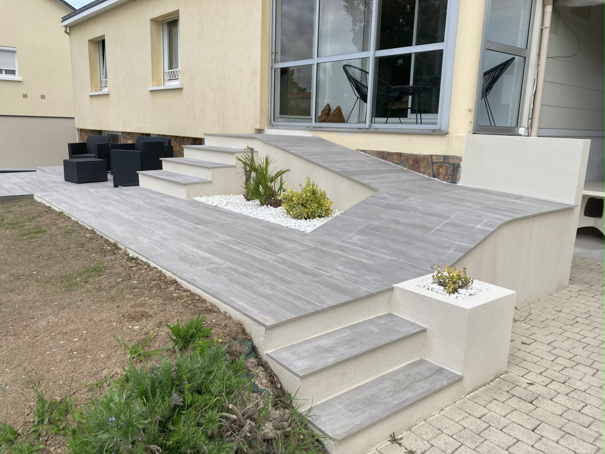 Terrasse moderne avec escalier et mobilier de jardin.