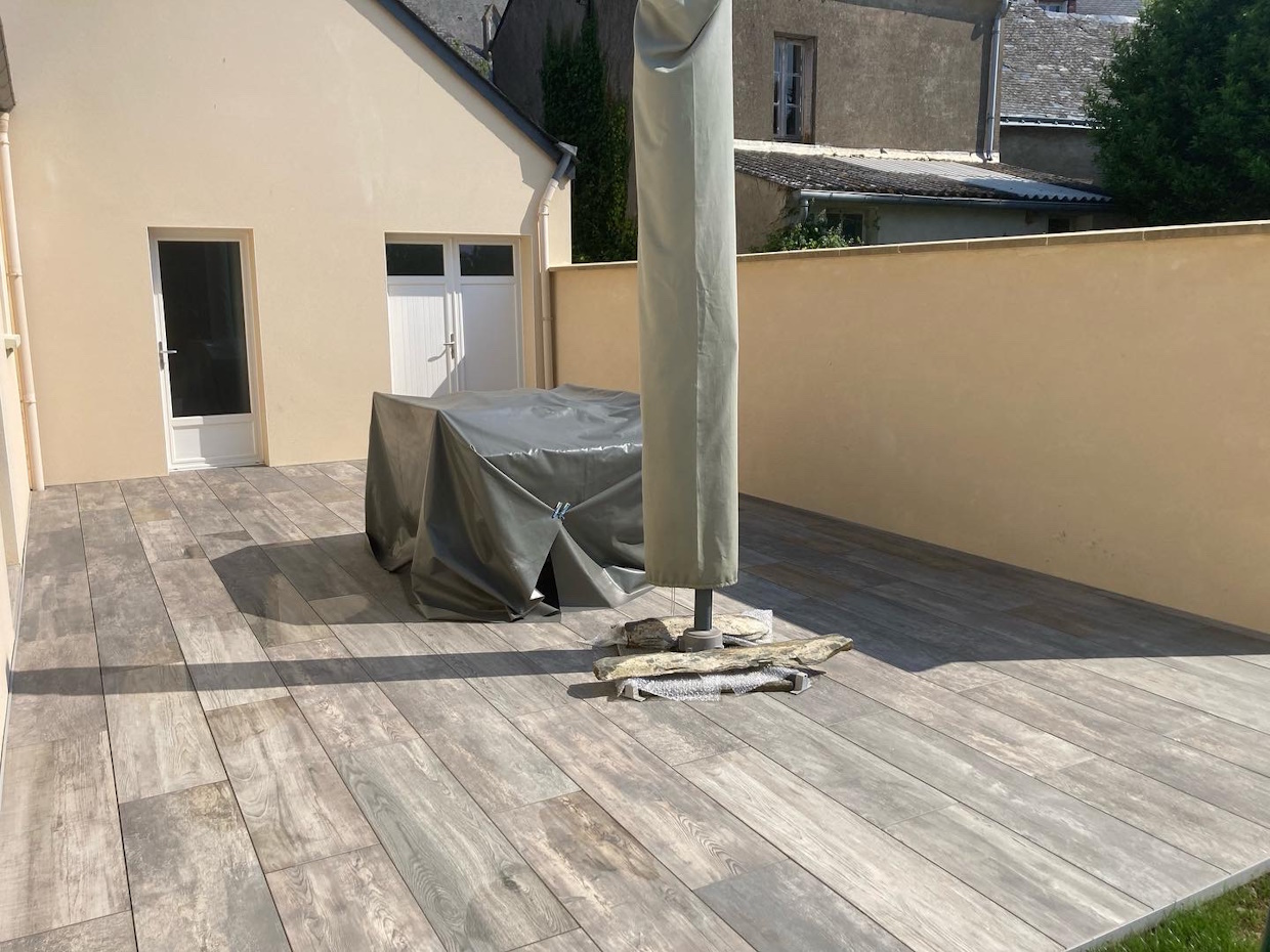 Terrasse moderne avec mobilier d'extérieur couvert.