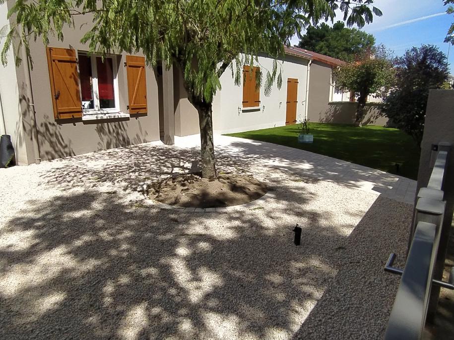 Jardin soigné avec maison et volets en bois.