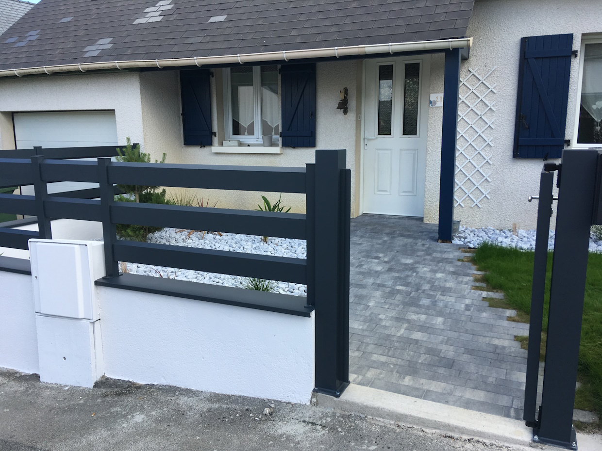 loire-amenagement-dallage-09 Maison moderne avec portail gris et volets bleus.