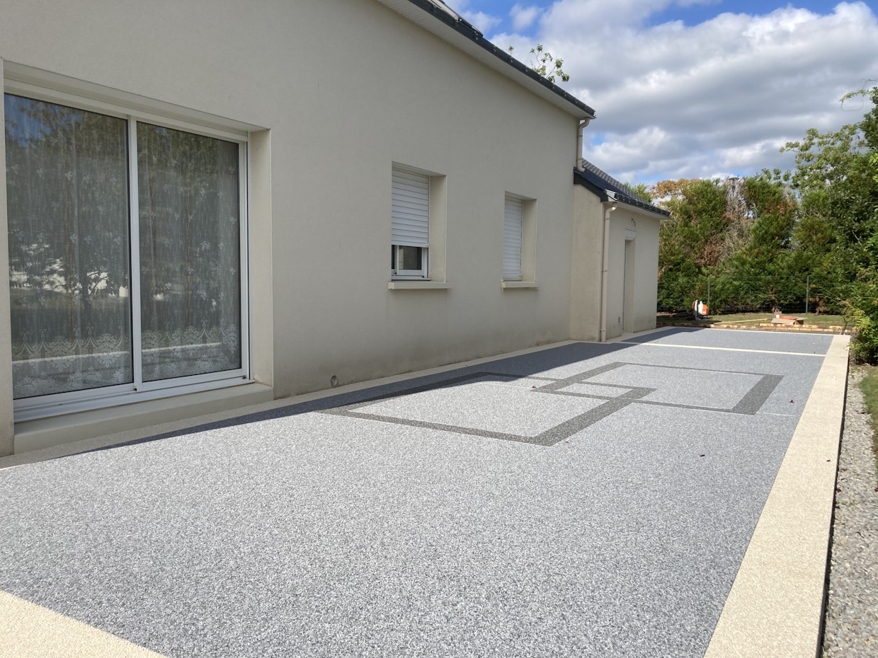 Maison moderne avec allée gravillonnée et jardin.