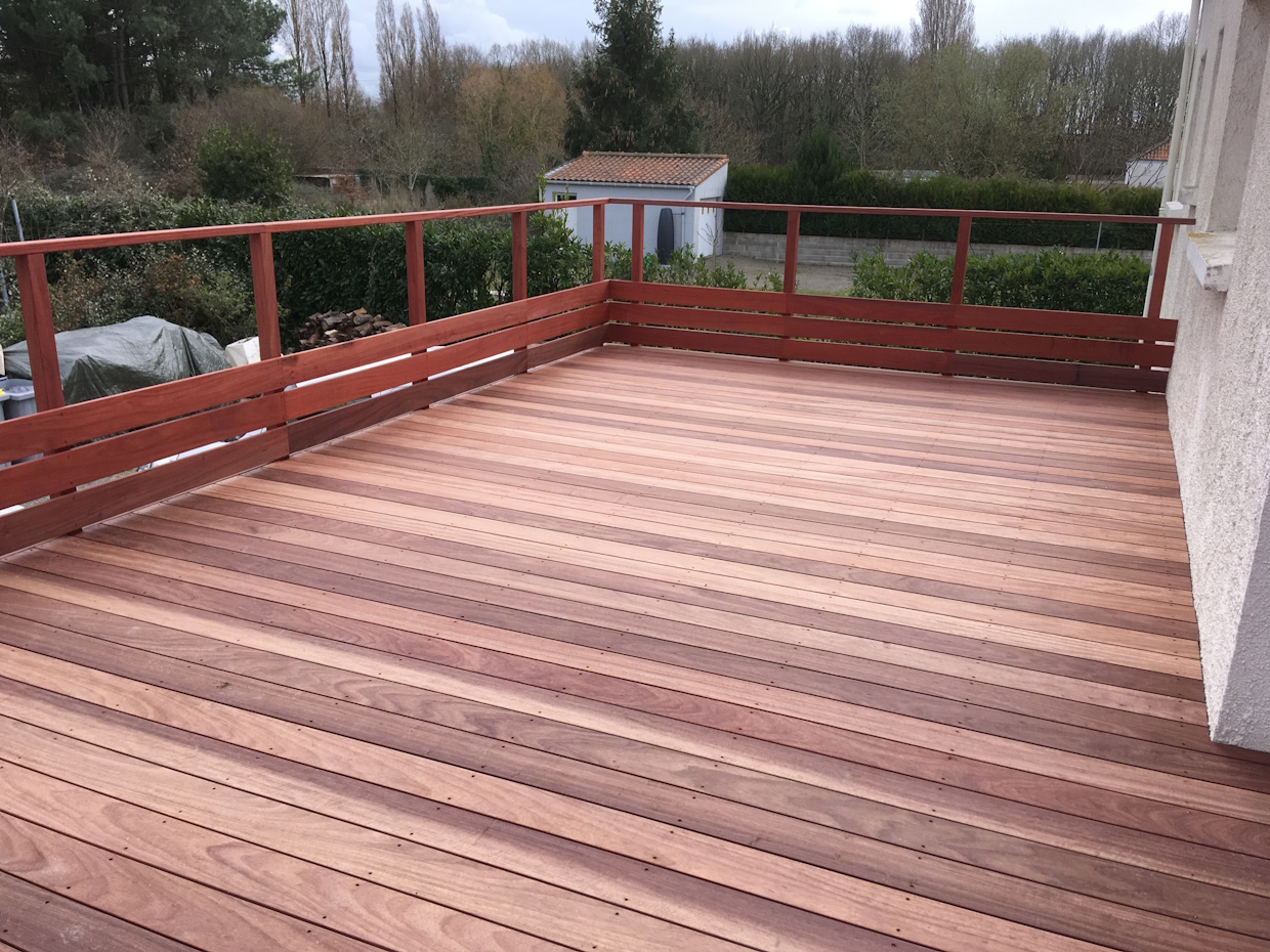 Terrasse extérieure en bois avec balustrade.