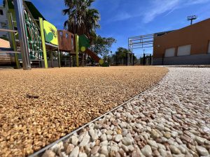 courdecole-apy-light2-300x225 Aire de jeux vide avec sol en caoutchouc et gravier.