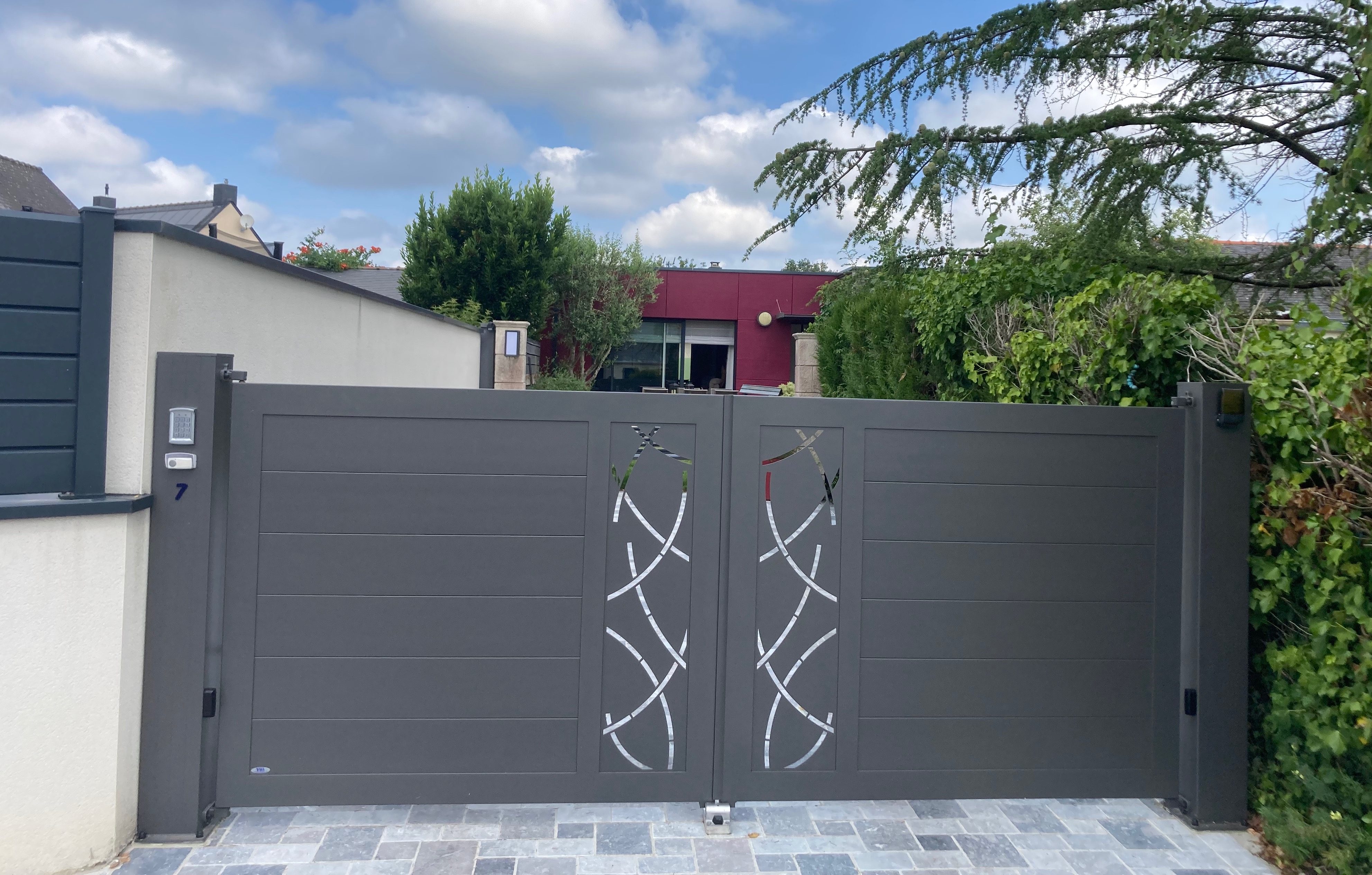 Portail moderne devant maison contemporaine.