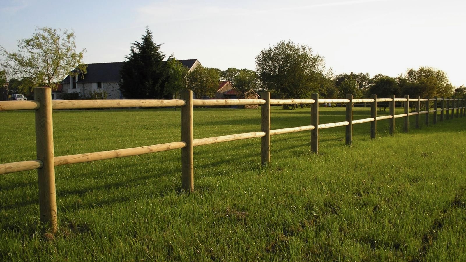 Clôture en bois champ verdoyant maison rurale France