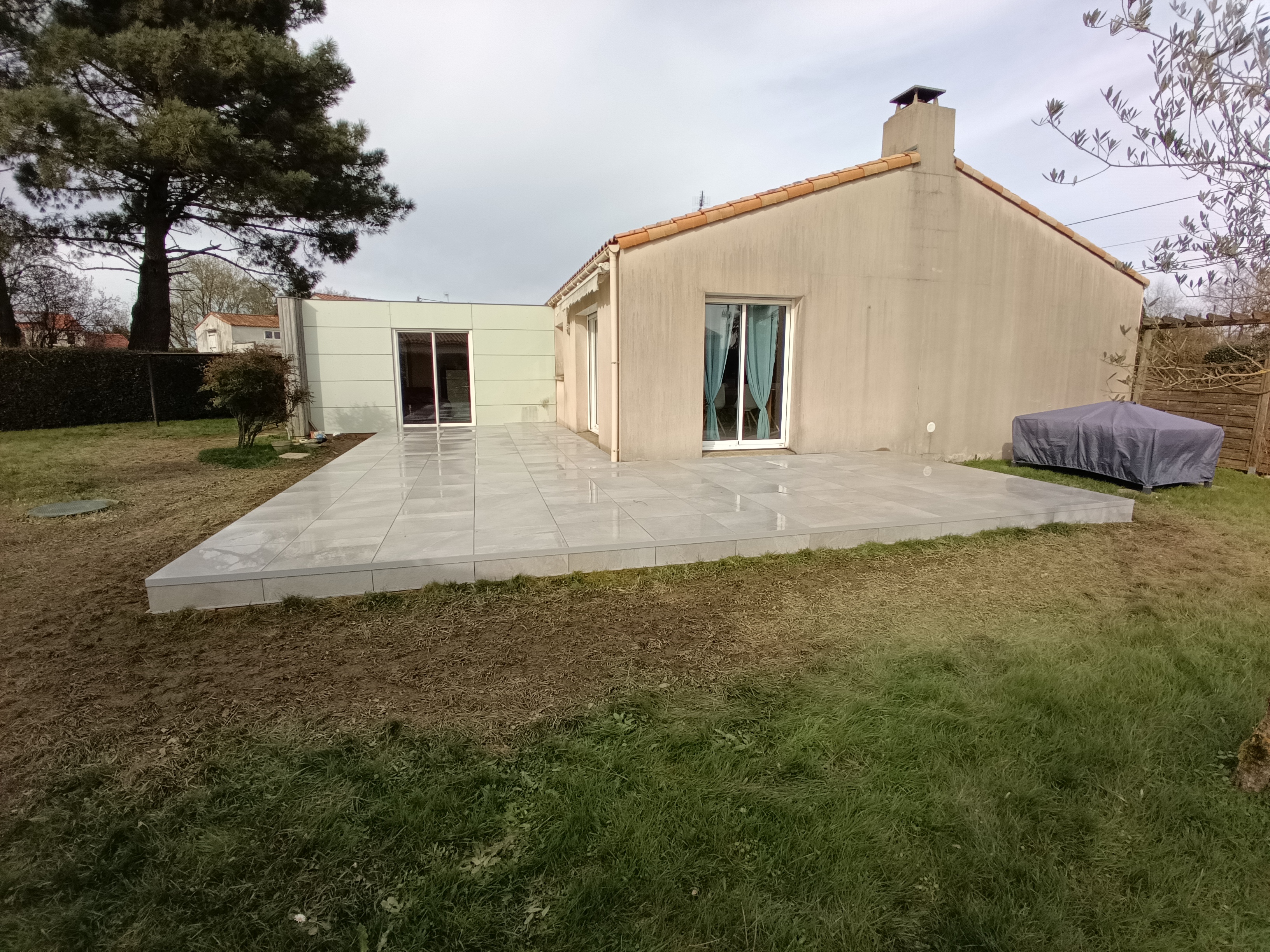 Maison moderne avec terrasse et jardin.