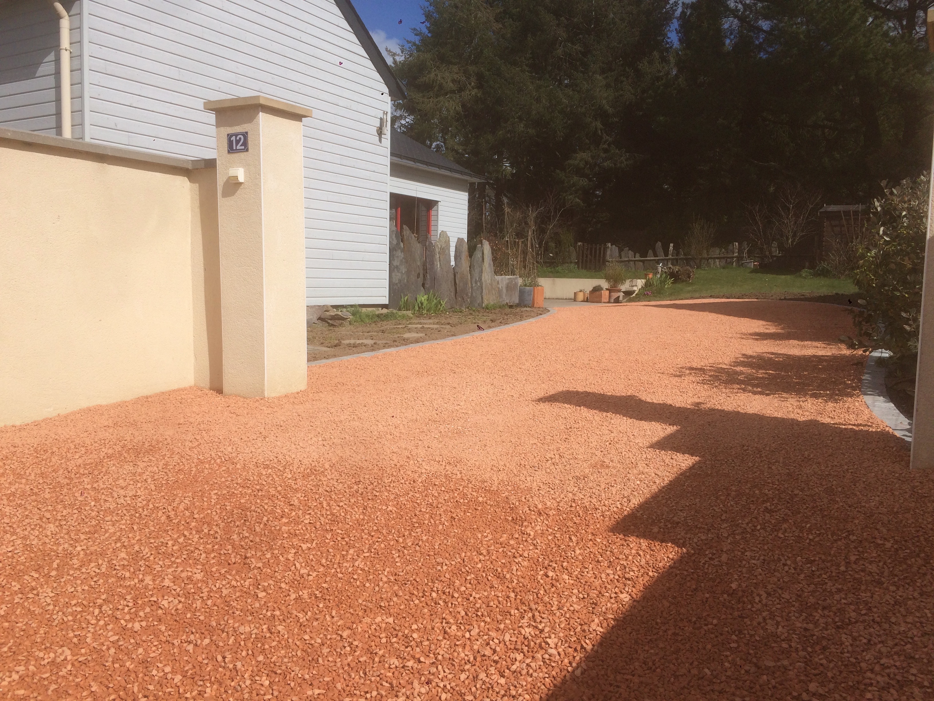 img 3341 Allée gravillonnée avec maison et jardin ensoleillés.