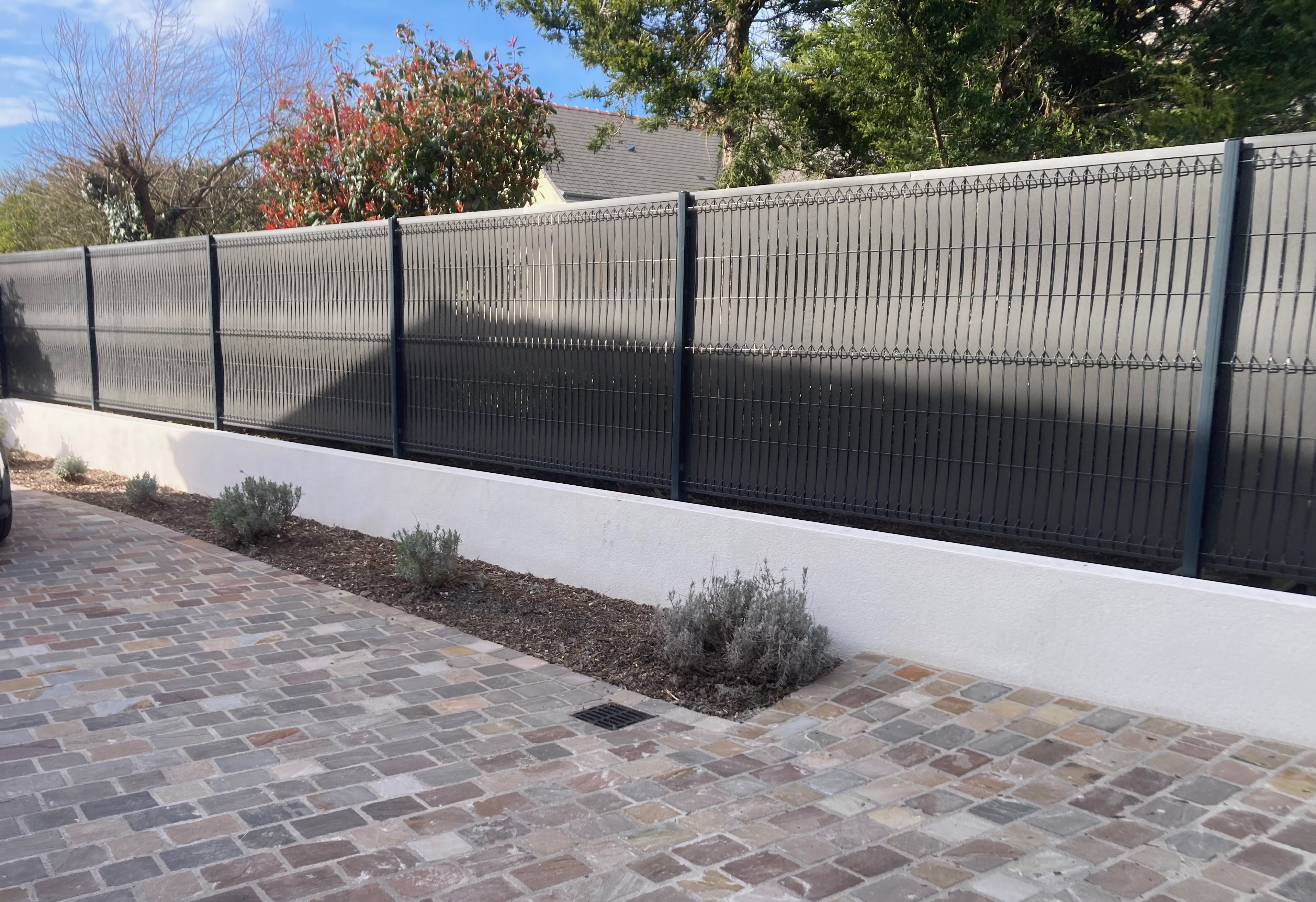 Clôture noire moderne et allée pavée