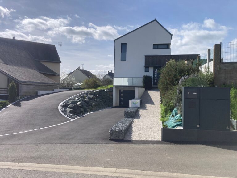 Maison contemporaine avec allée sinueuse et jardin paysager.