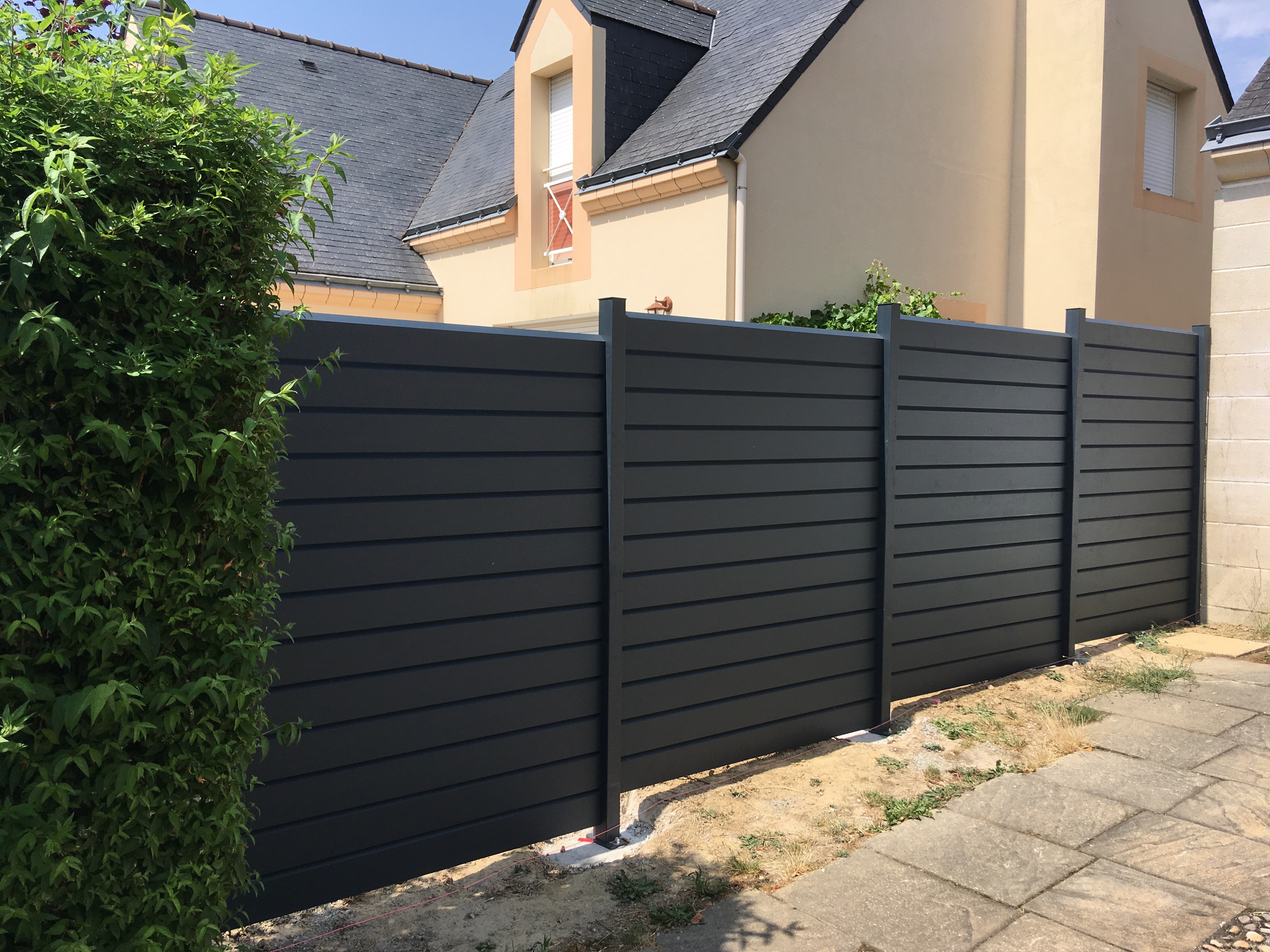 Clôture extérieure moderne grise dans un jardin résidentiel.