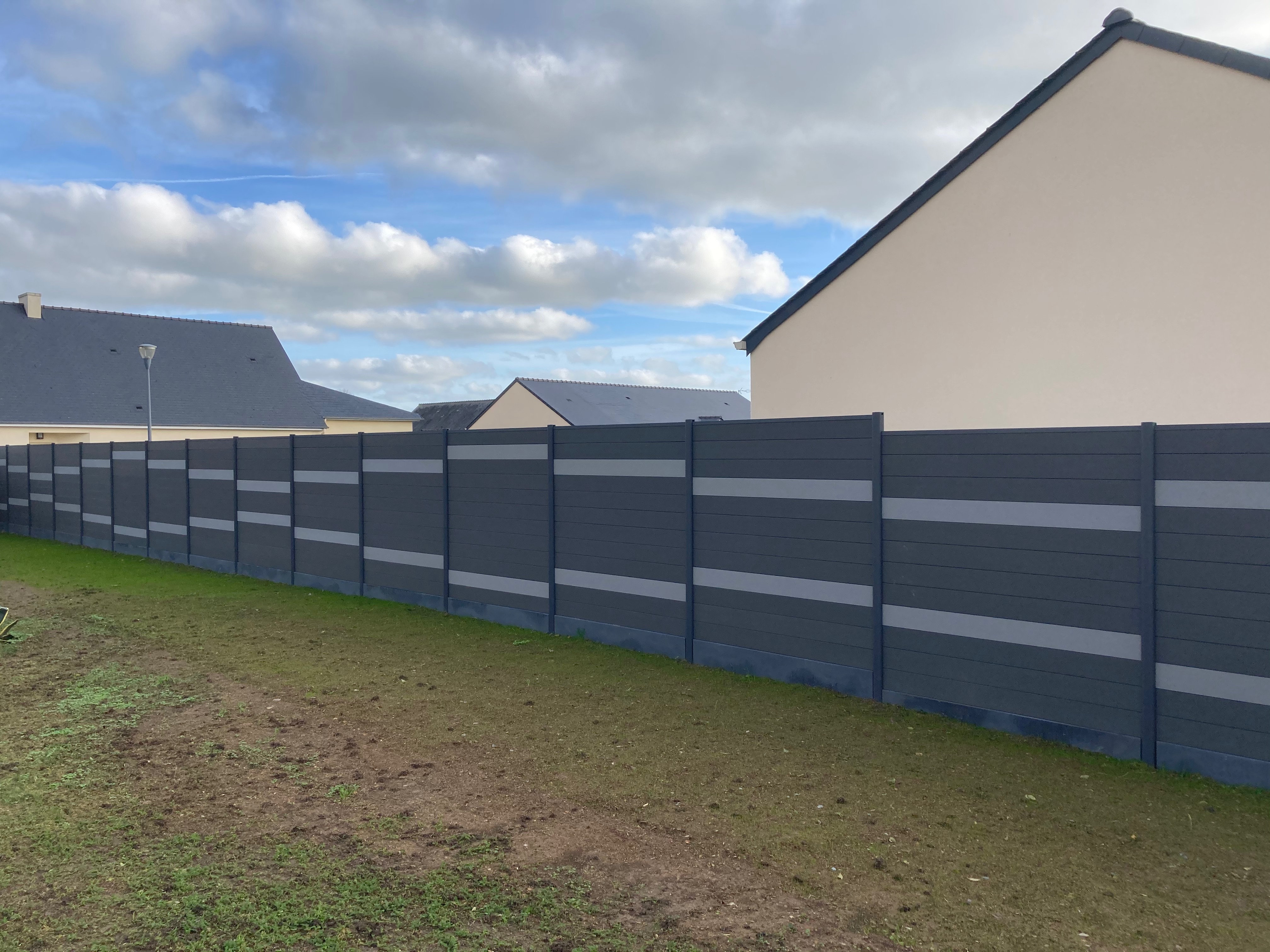 Clôture moderne rayée en banlieue résidentielle.