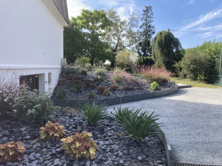 Jardin paysager devant maison contemporaine.